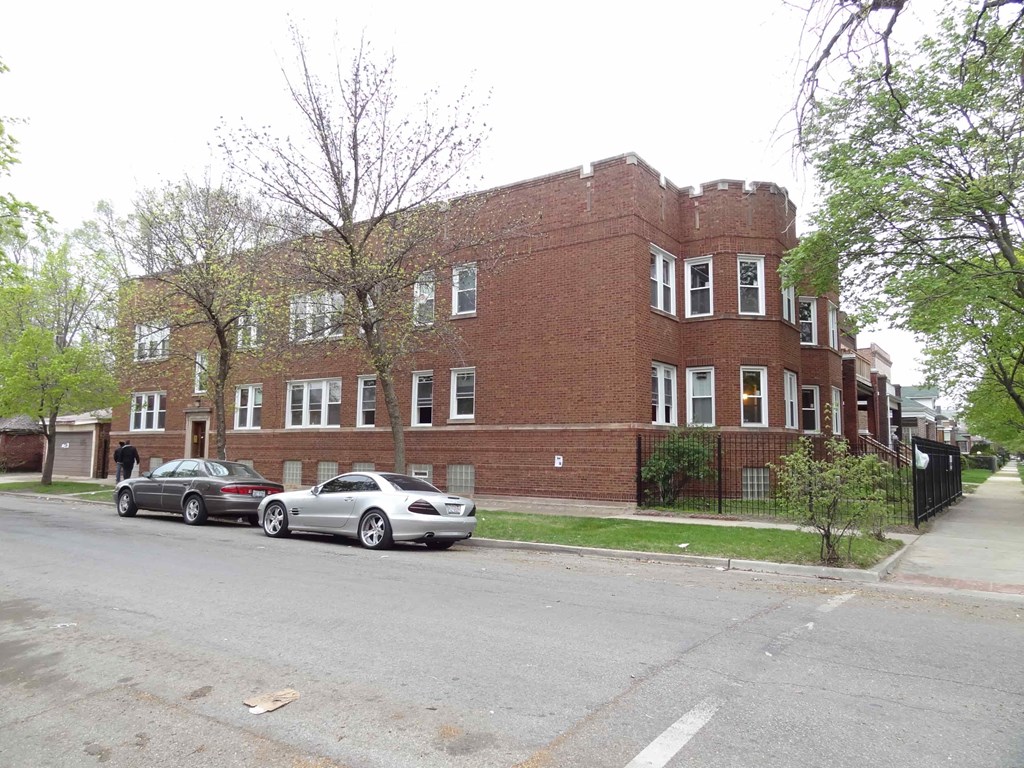 a large brick building with cars parked in front of it