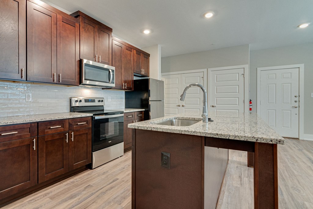 a kitchen with wooden cabinets and granite counter tops and a sink