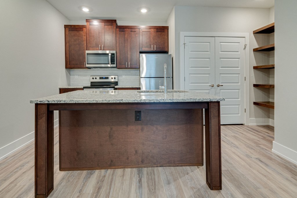 an empty kitchen with a granite counter top and