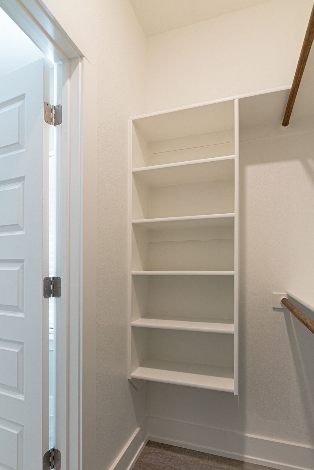 a small closet with shelves and a white door