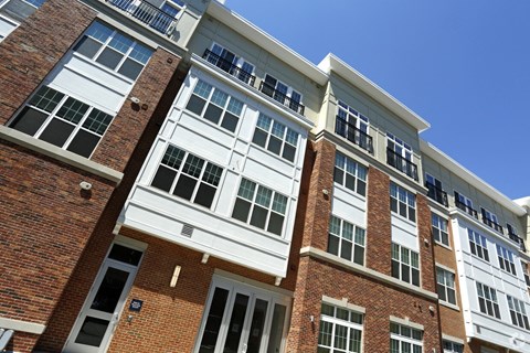 the exterior of an apartment building with brick and white windows