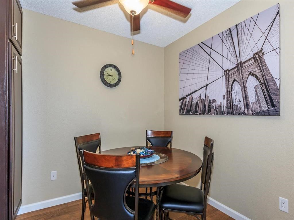 a dining room with a table and chairs and a clock on the wall