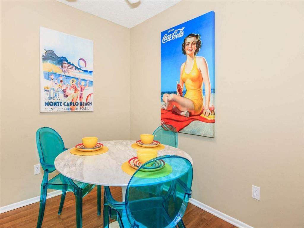 a dining room with a table and chairs and a poster on the wall
