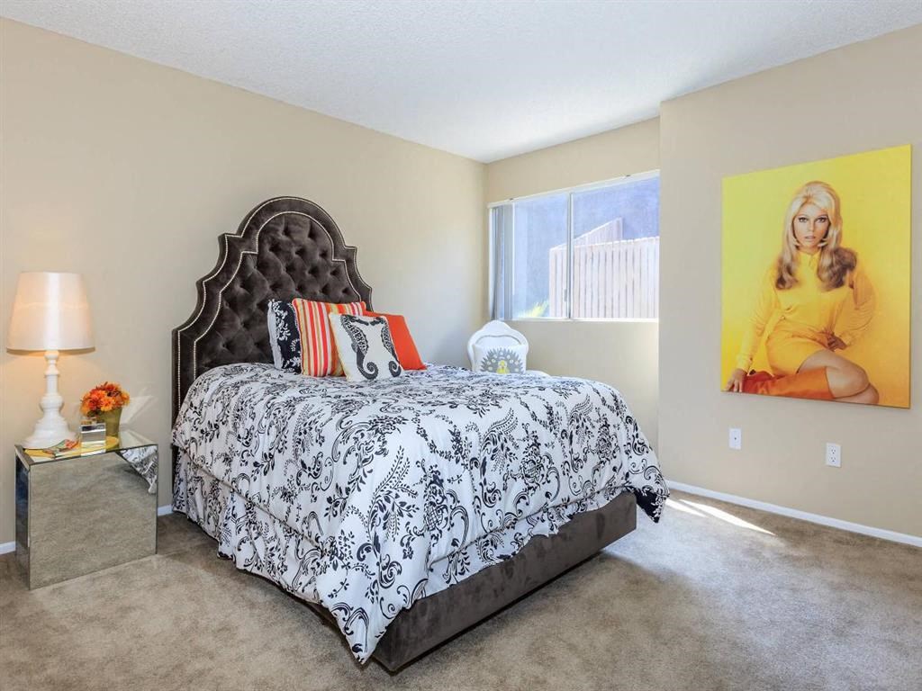 a bedroom with a bed and a painting on the wall