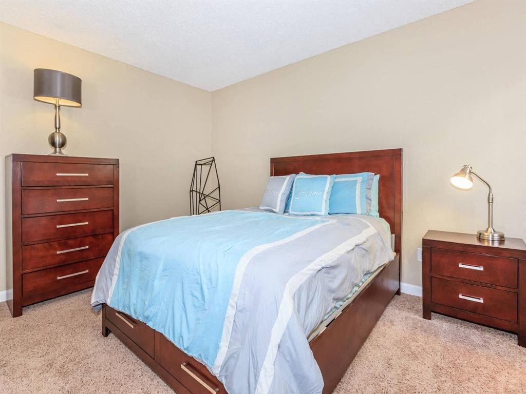 a bedroom with a bed and two dressers