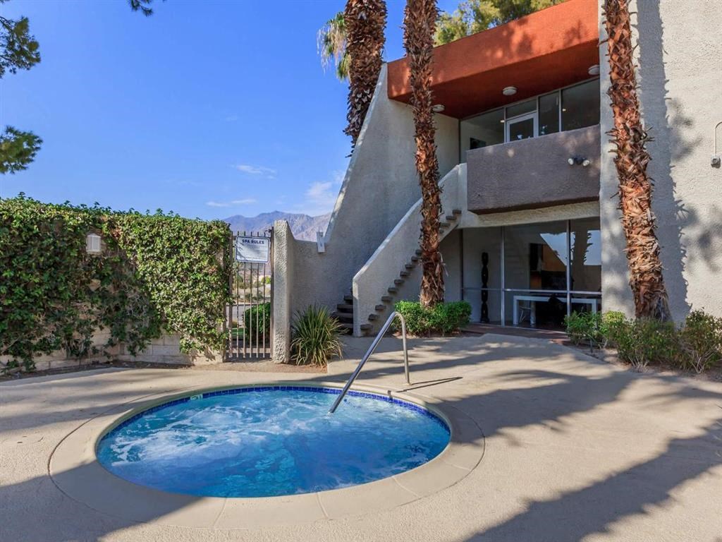 a hot tub in front of a house with palm trees
