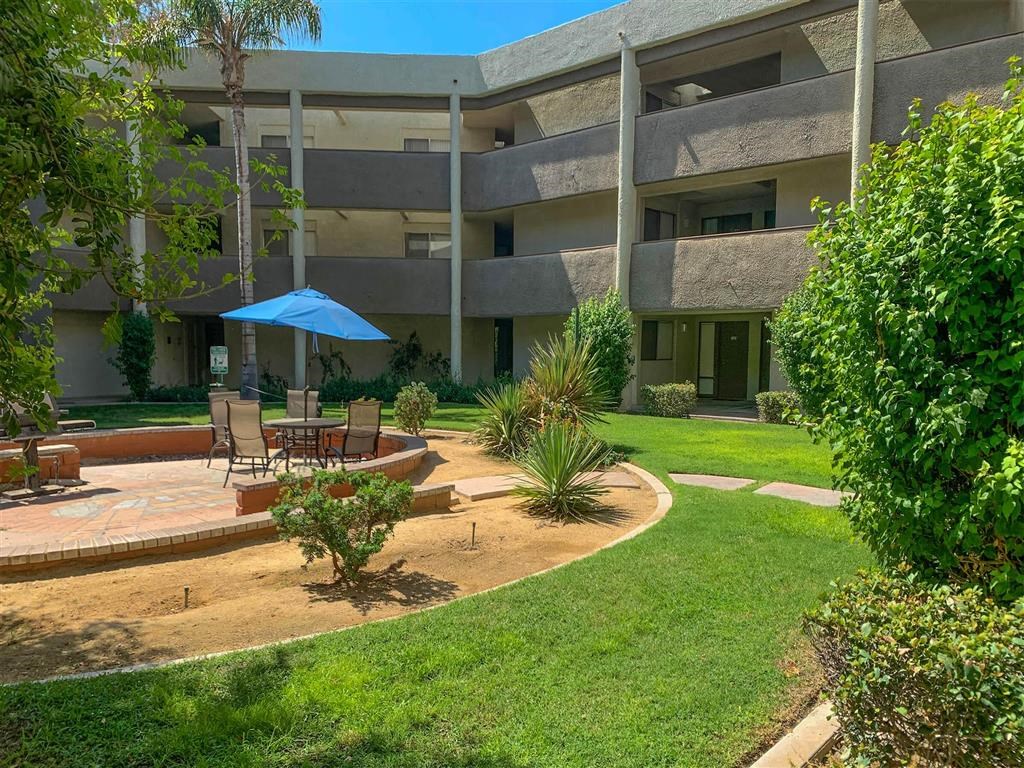 a patio with a table and chairs in front of a building