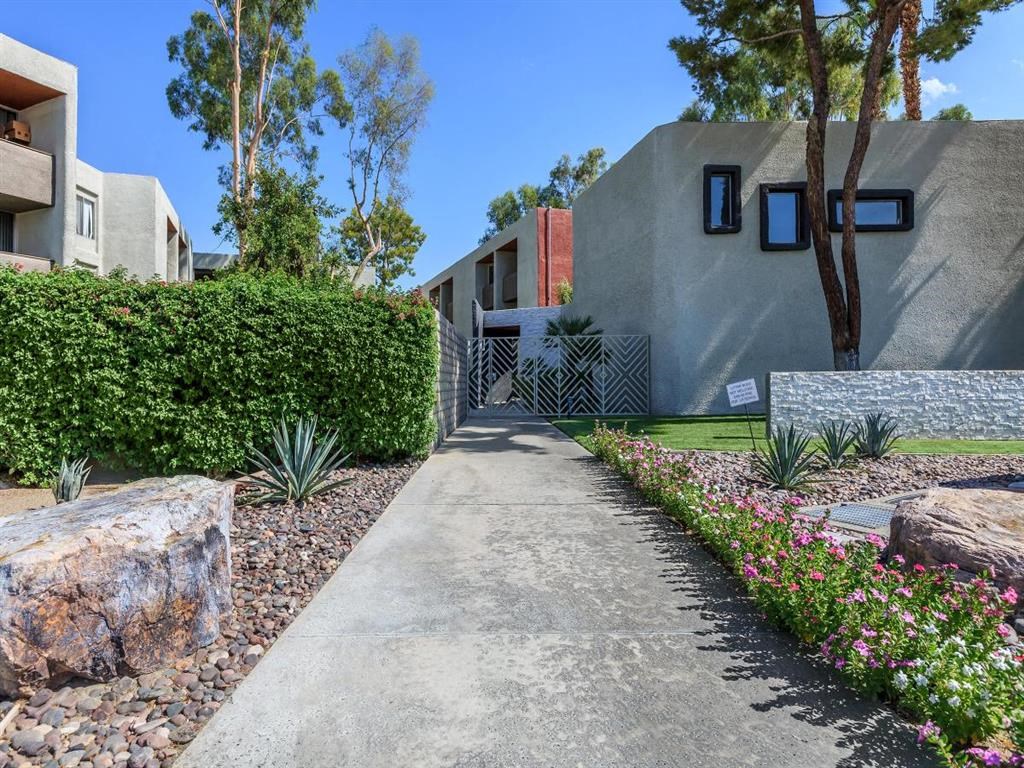 a path leading up to a building with trees and plants