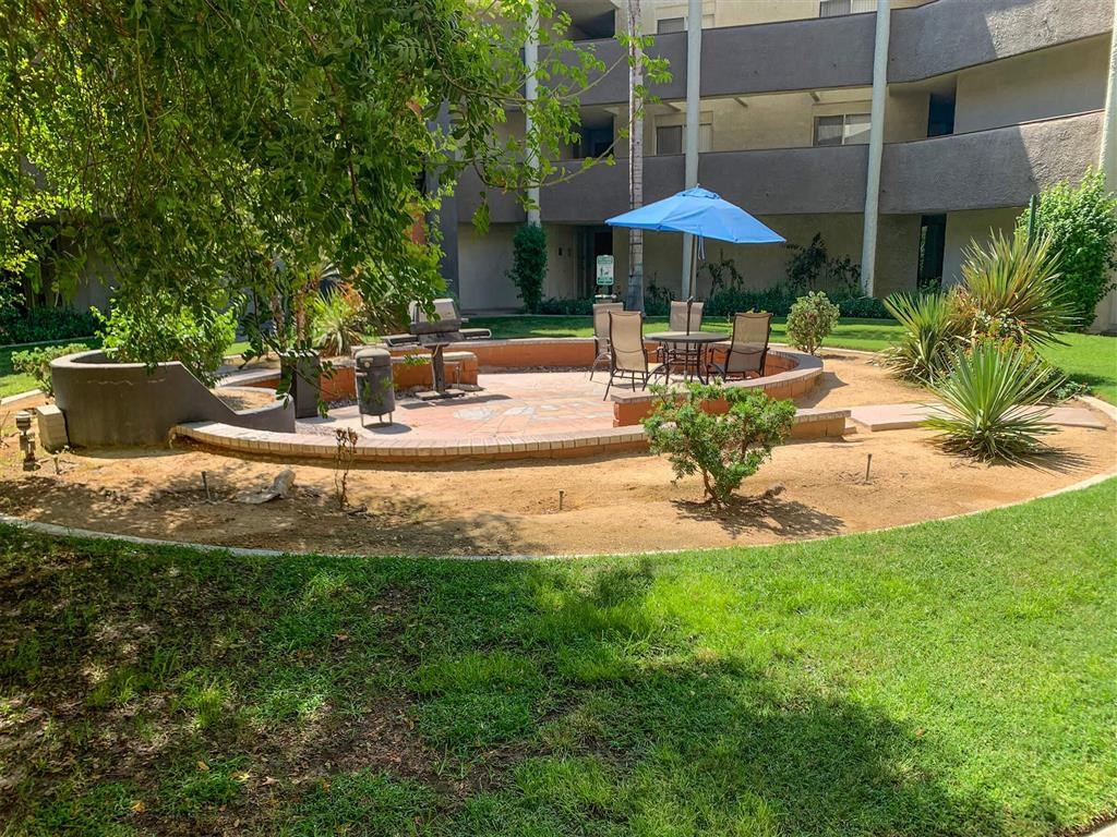 a courtyard with a table and chairs in front of a building