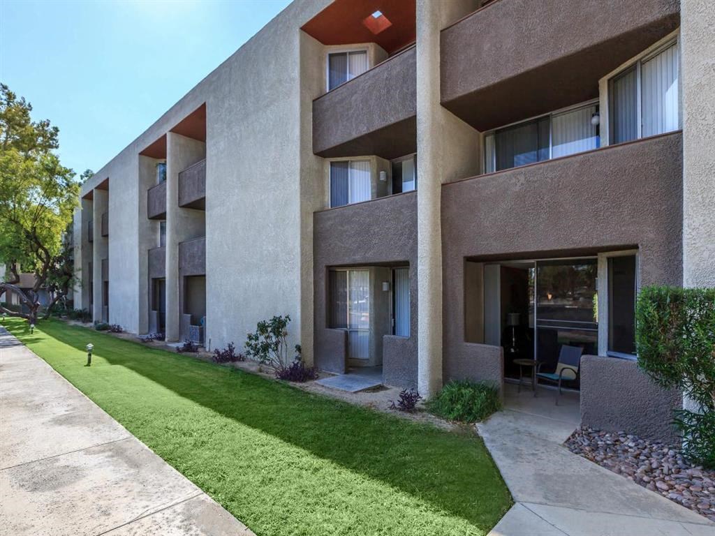 an apartment building with a lawn in front of it