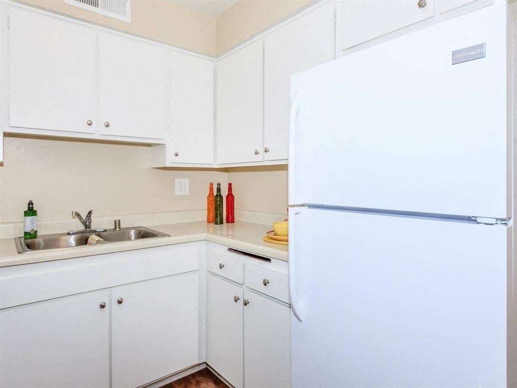 a kitchen with white cabinets and a white refrigerator