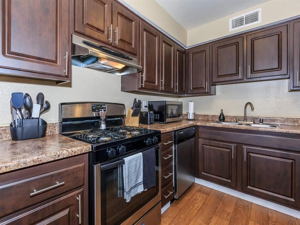 a kitchen with wooden cabinets and stainless steel appliances