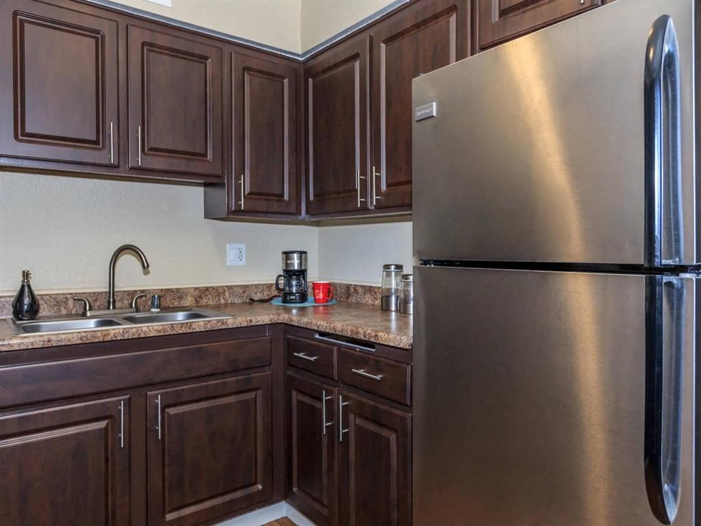 a kitchen with stainless steel appliances and wooden cabinets