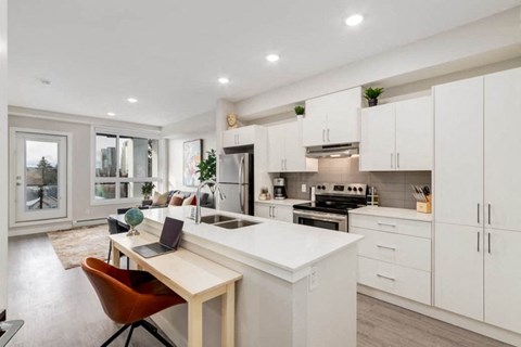 a kitchen with an island and a table with a laptop