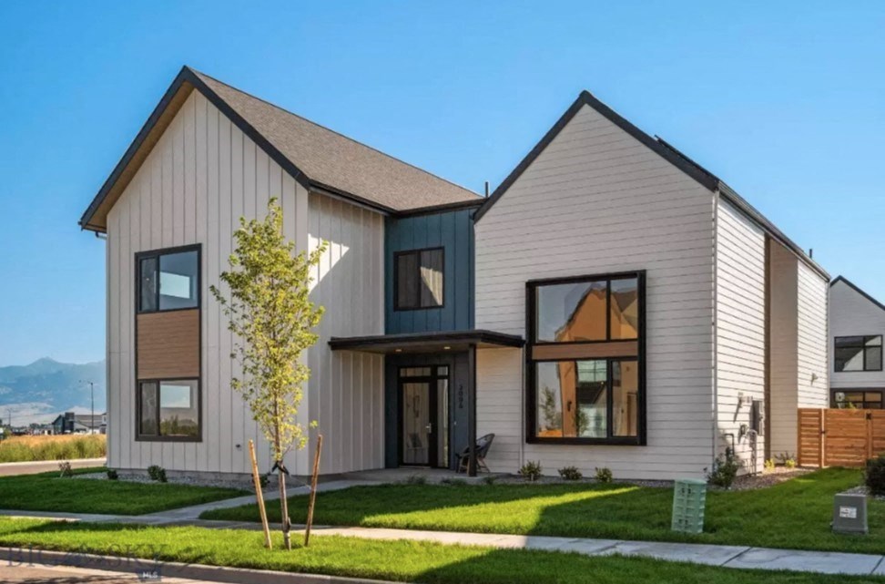 the exterior of a home with white siding and black windows