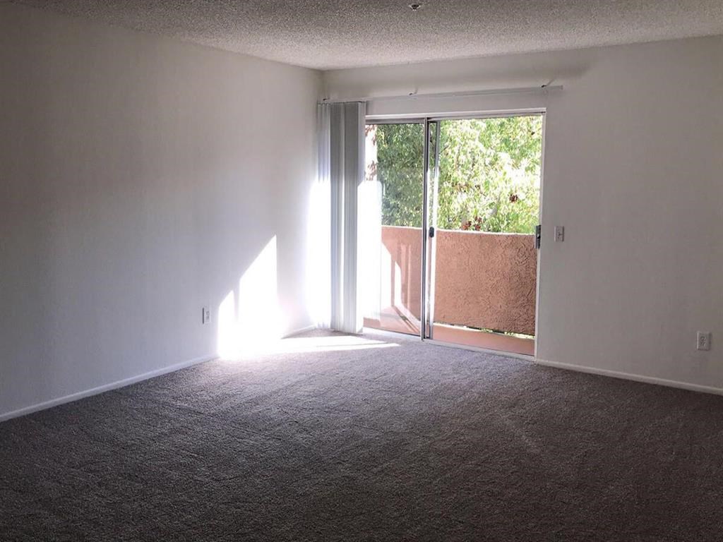 an empty living room with a sliding glass door