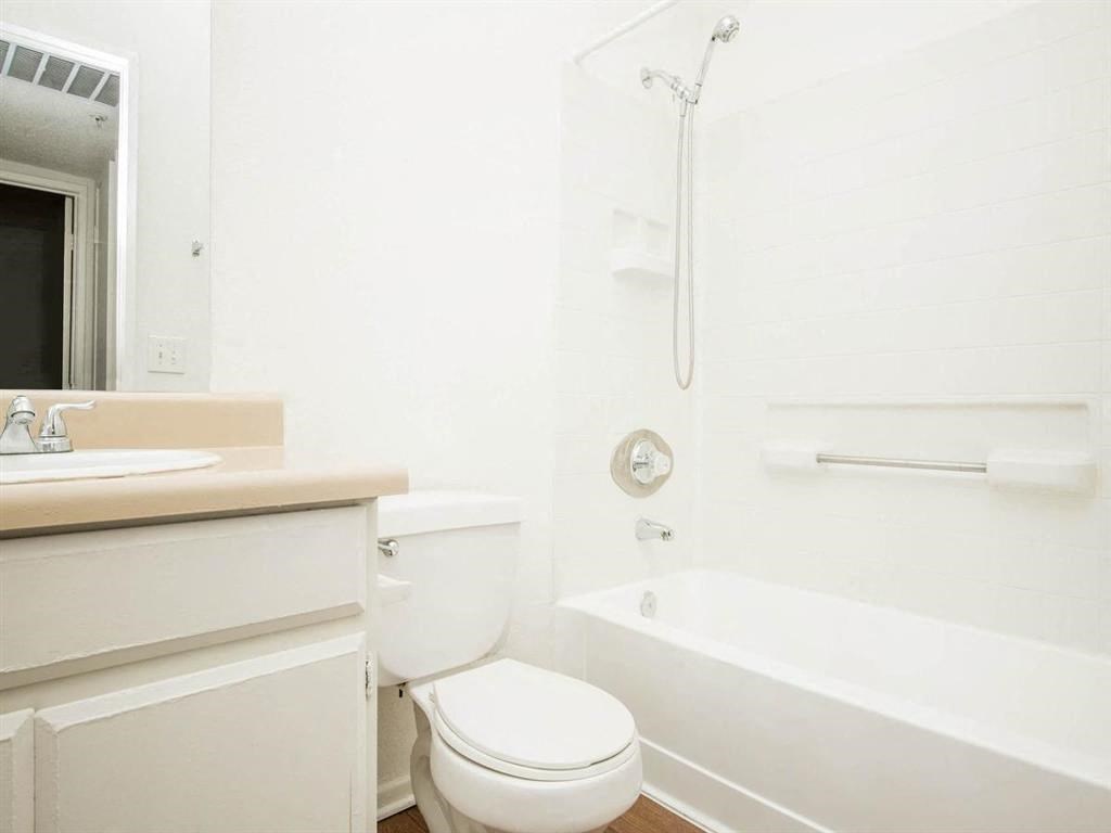 a bathroom with a toilet and a tub and a sink