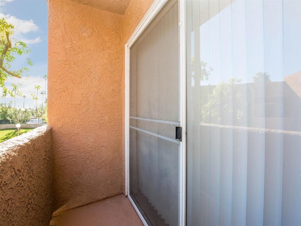 a patio with a sliding glass door and a balcony