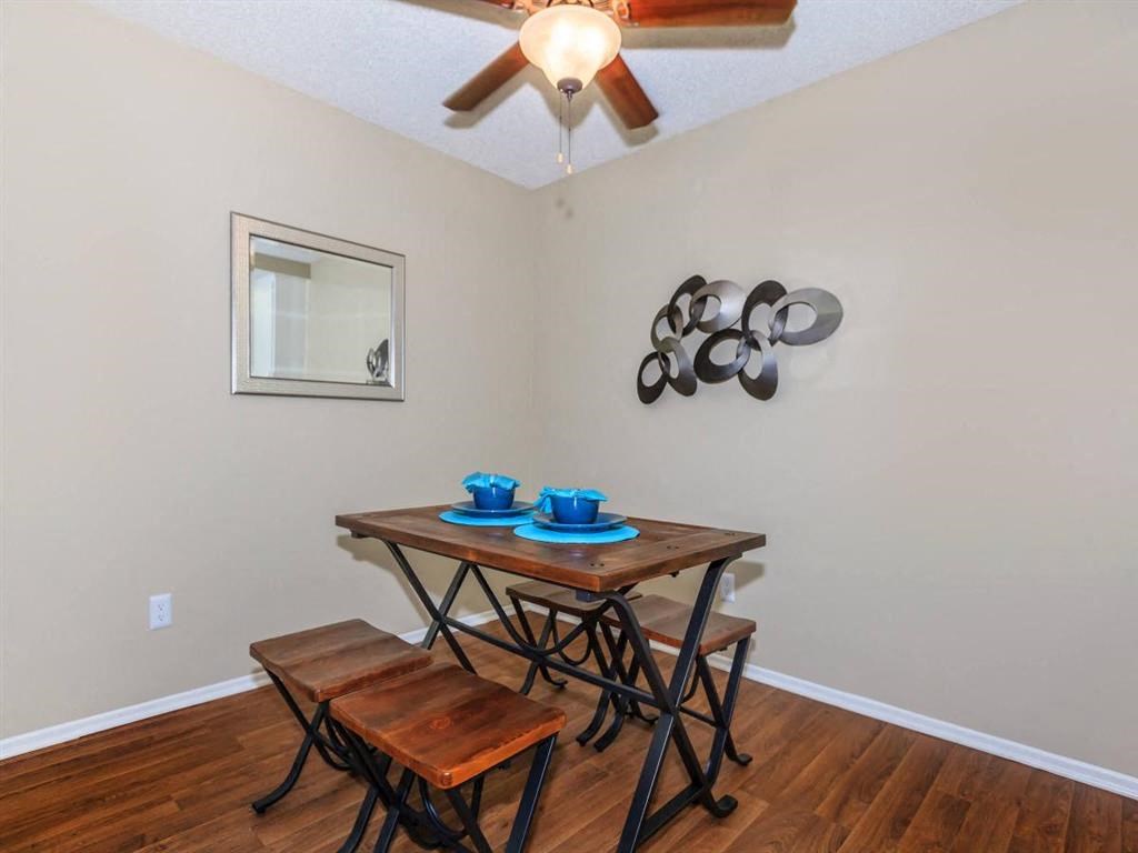 a dining room with a table and chairs and a ceiling fan