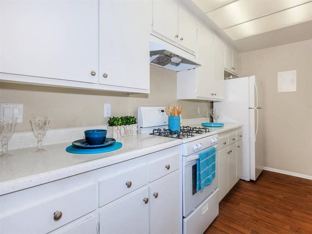 a kitchen with white cabinets and a stove and a refrigerator