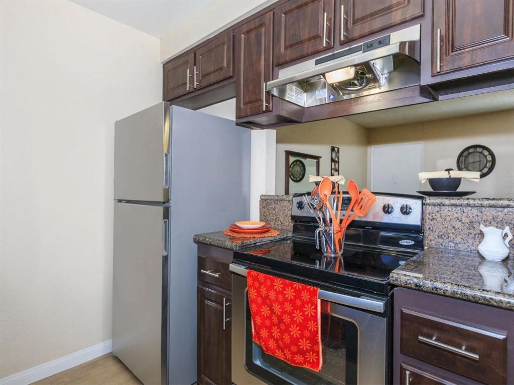 a kitchen with a stainless steel refrigerator and stove