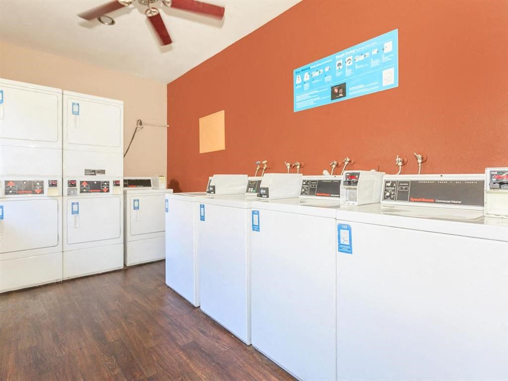 a group of white appliances in a room with an orange wall