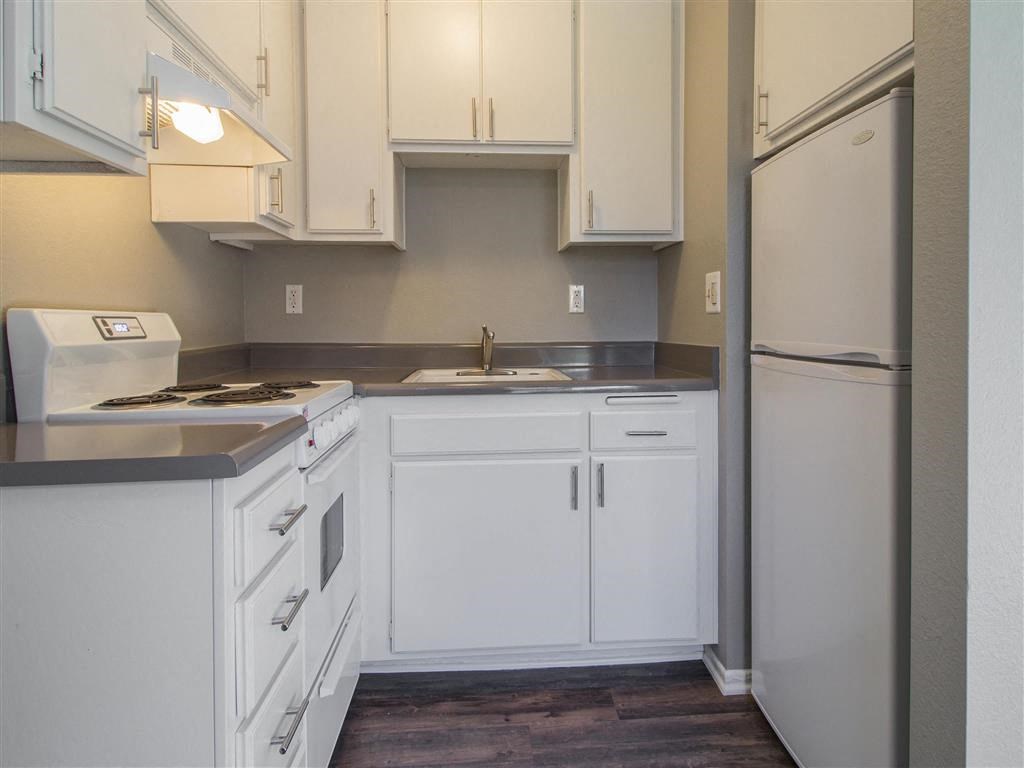 a kitchen with white cabinets and a refrigerator