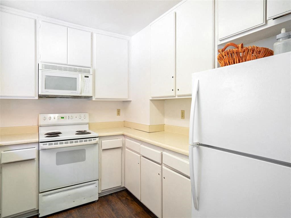 a white kitchen with white appliances and white cabinets