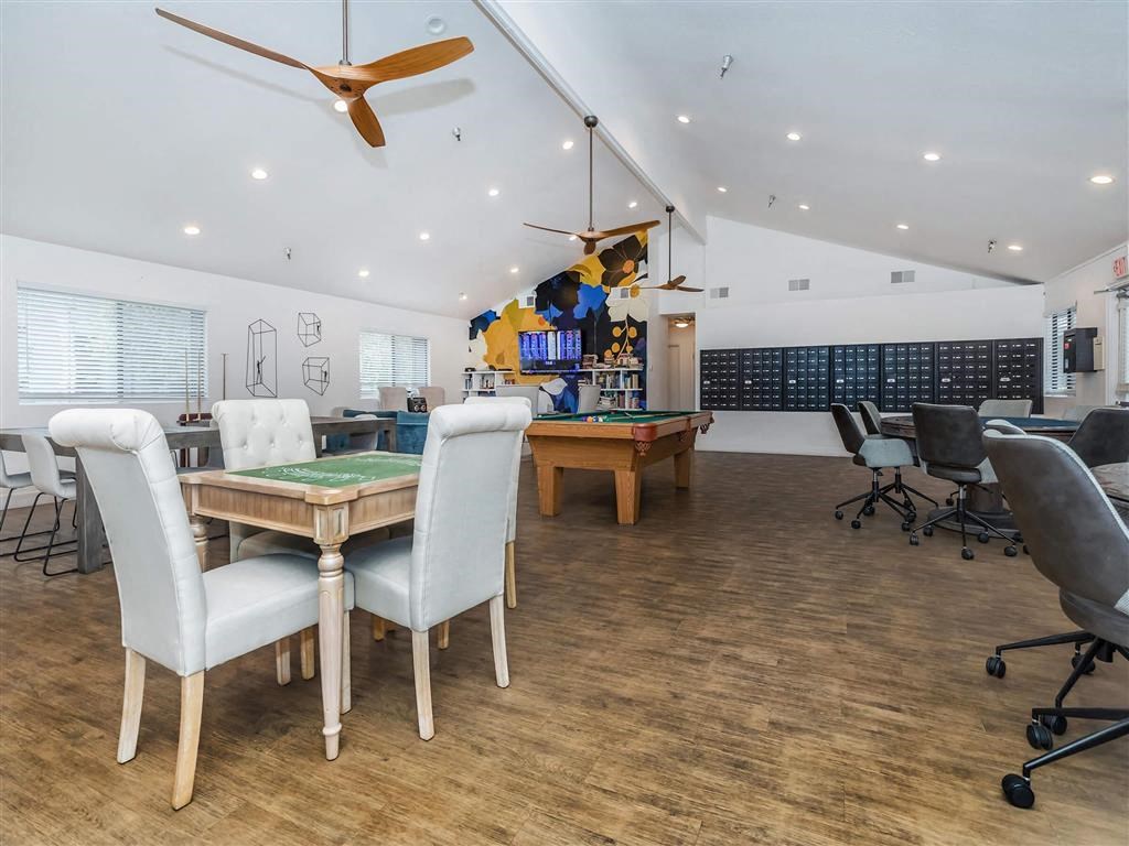 a game room with tables and chairs and a pool table
