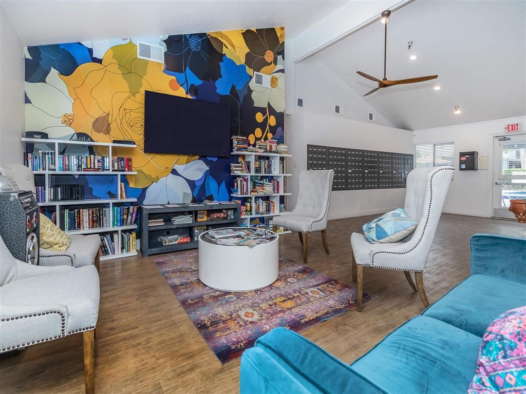 a living room with a blue couch and chairs and a television