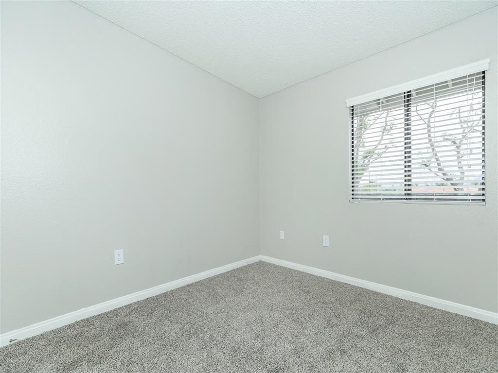 an empty room with a window and carpet