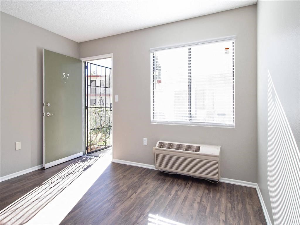an empty living room with a window and a door
