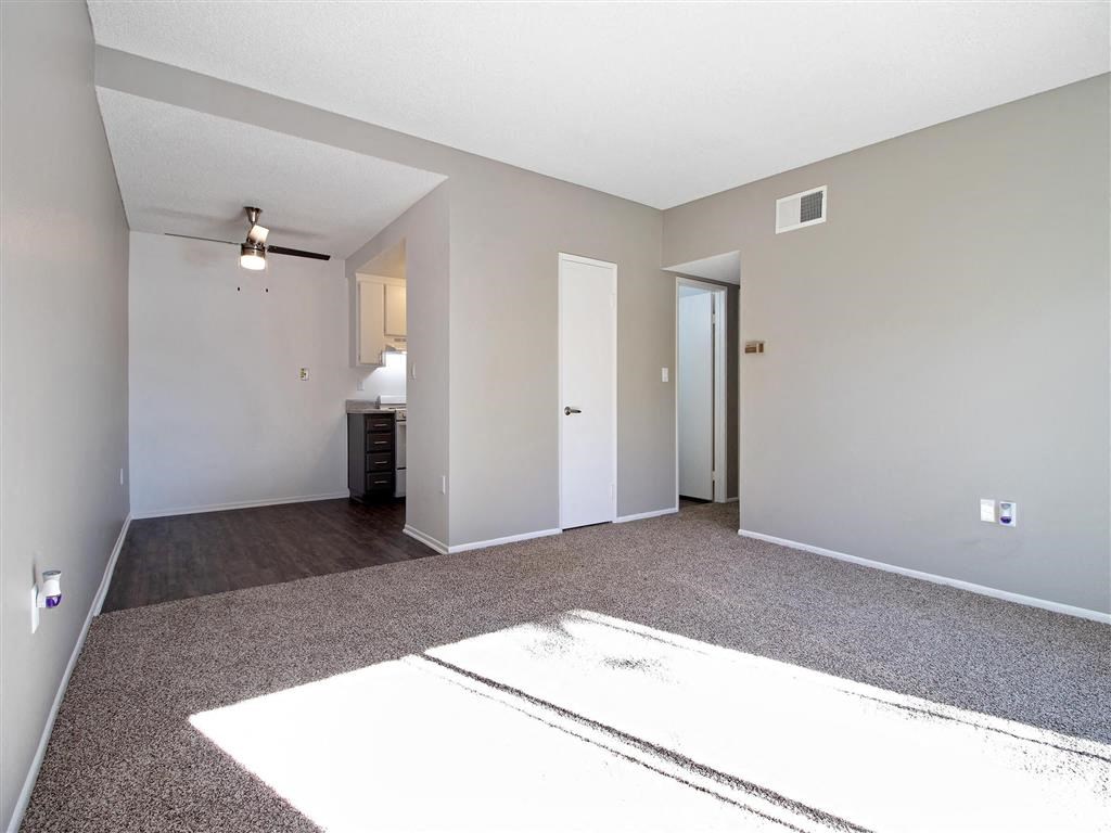 an empty living room with white walls and carpet