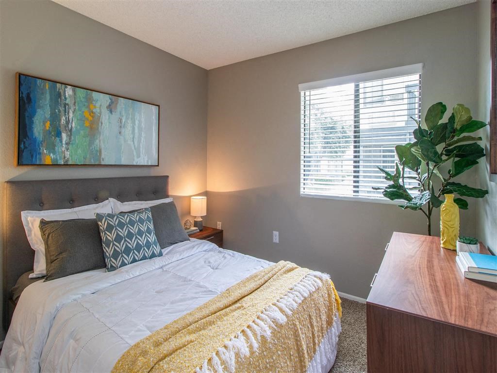 a bedroom with a bed and a painting on the wall