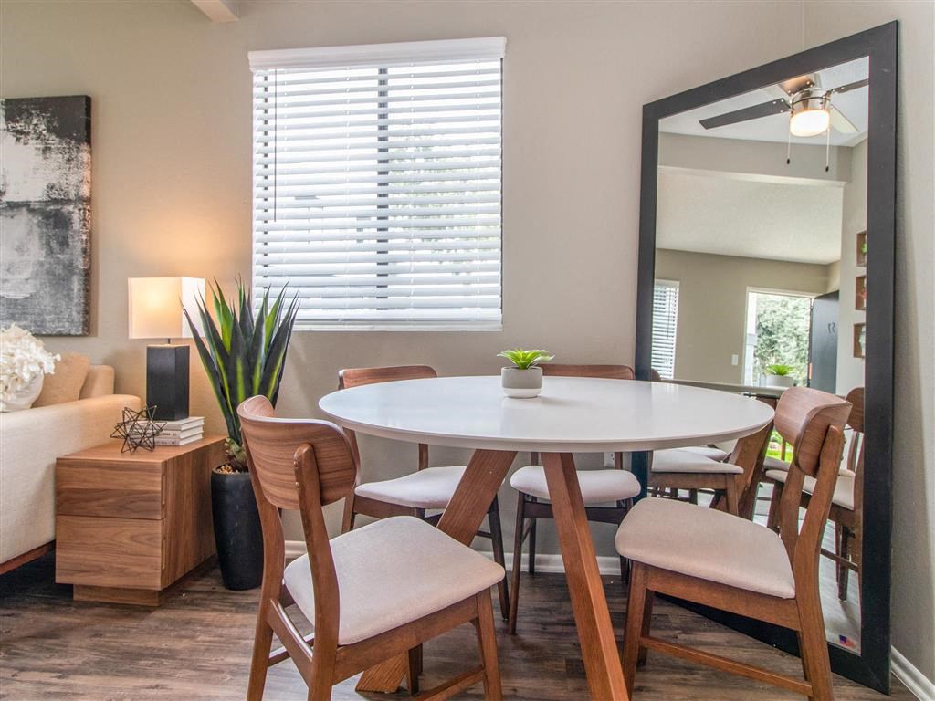 a dining room with a table and chairs and a mirror