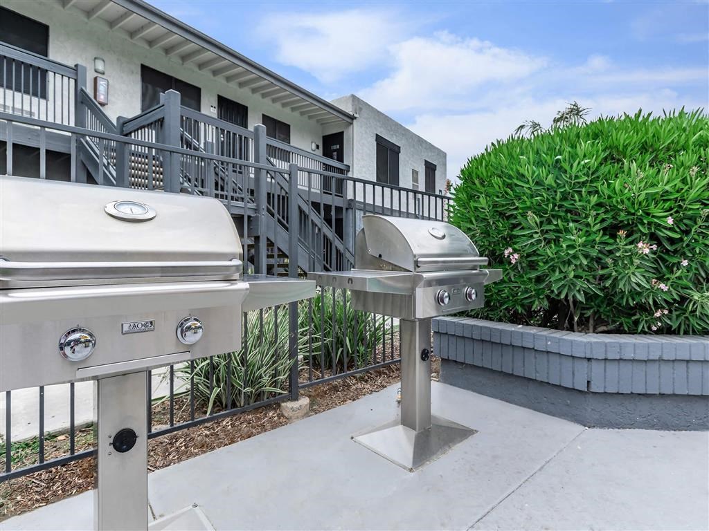 two bbq pits in front of a building with stairs