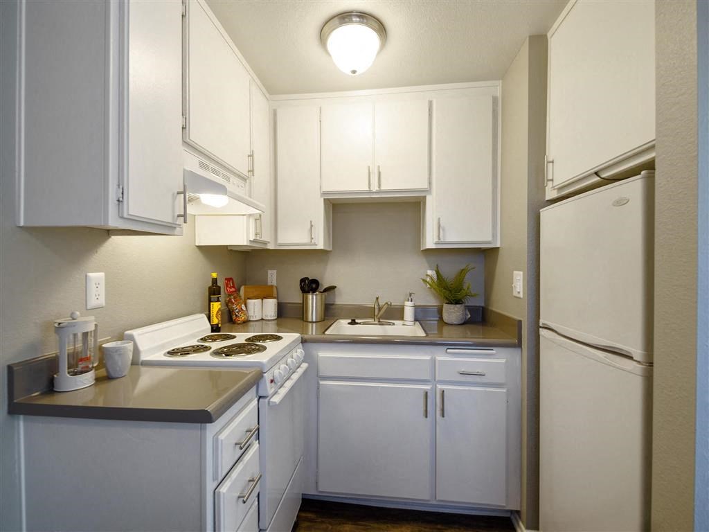 a kitchen with white cabinets and a white refrigerator