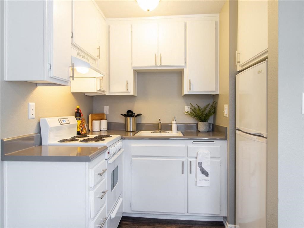 a white kitchen with white cabinets and a refrigerator