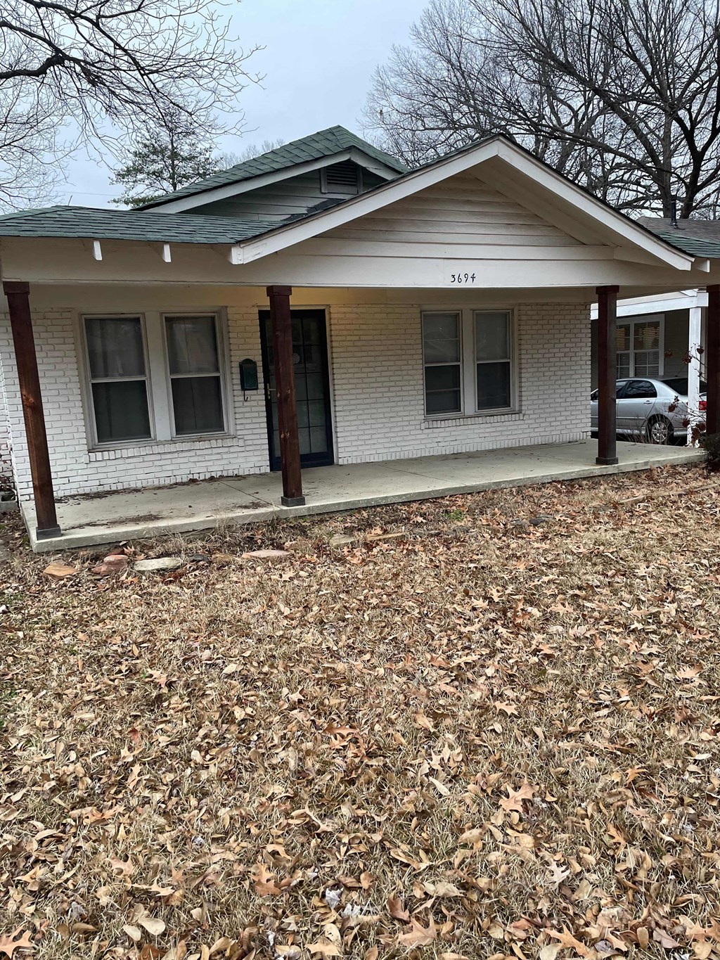 a white brick house with a porch and a driveway