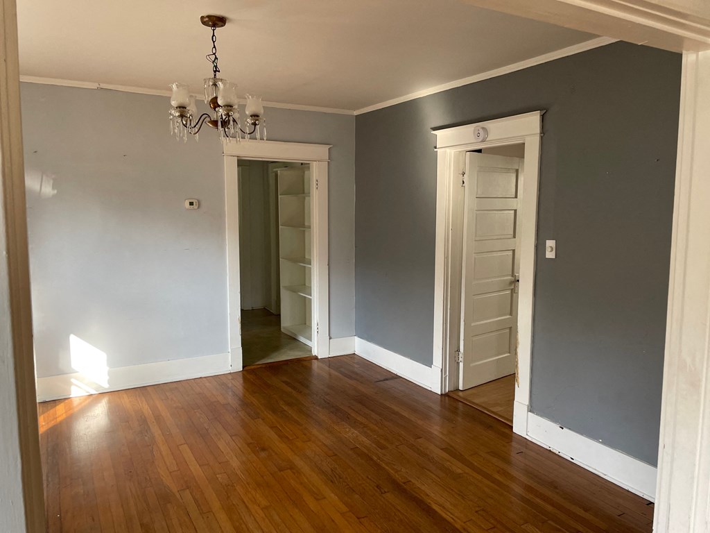a living room with blue walls and a wooden floor and a closet with two doors