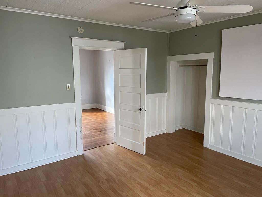 an empty living room with wood floors and an open door