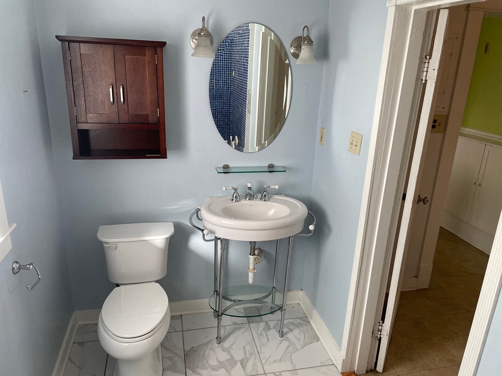a bathroom with a toilet and a sink and a mirror