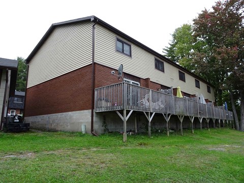 A house with a red brick wall and a wooden deck.