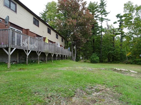 A house with a deck and trees in the background.