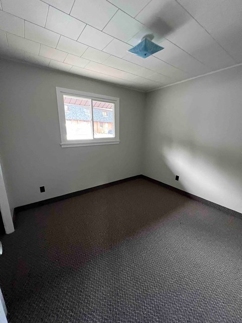 A room with a window and a ceiling light.