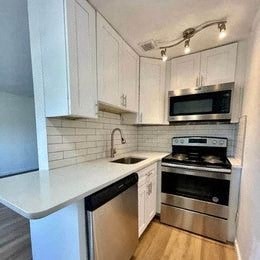 a small kitchen with white cabinets and a sink