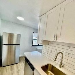 a kitchen with a sink and a stainless steel refrigerator