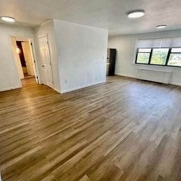 an empty living room with a hard wood floor