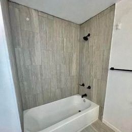 a bathroom with a white tub and a shower