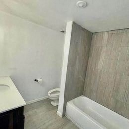 a bathroom with a tub and a toilet and a sink